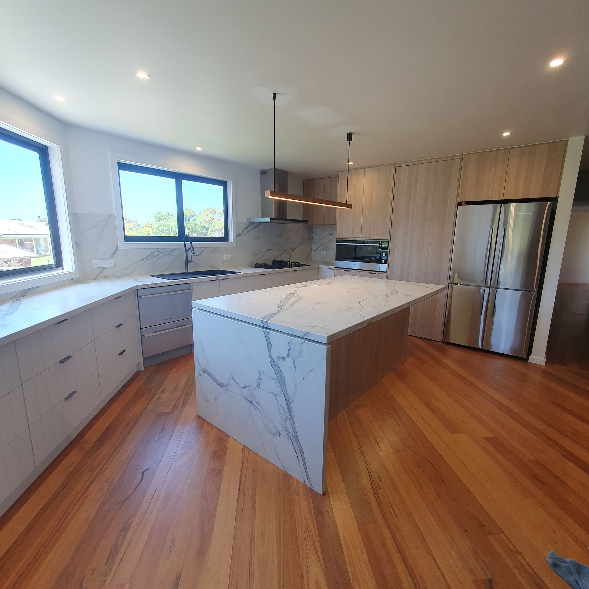 A kitchen with a large island and stainless steel appliances | Building Services | Coastyle