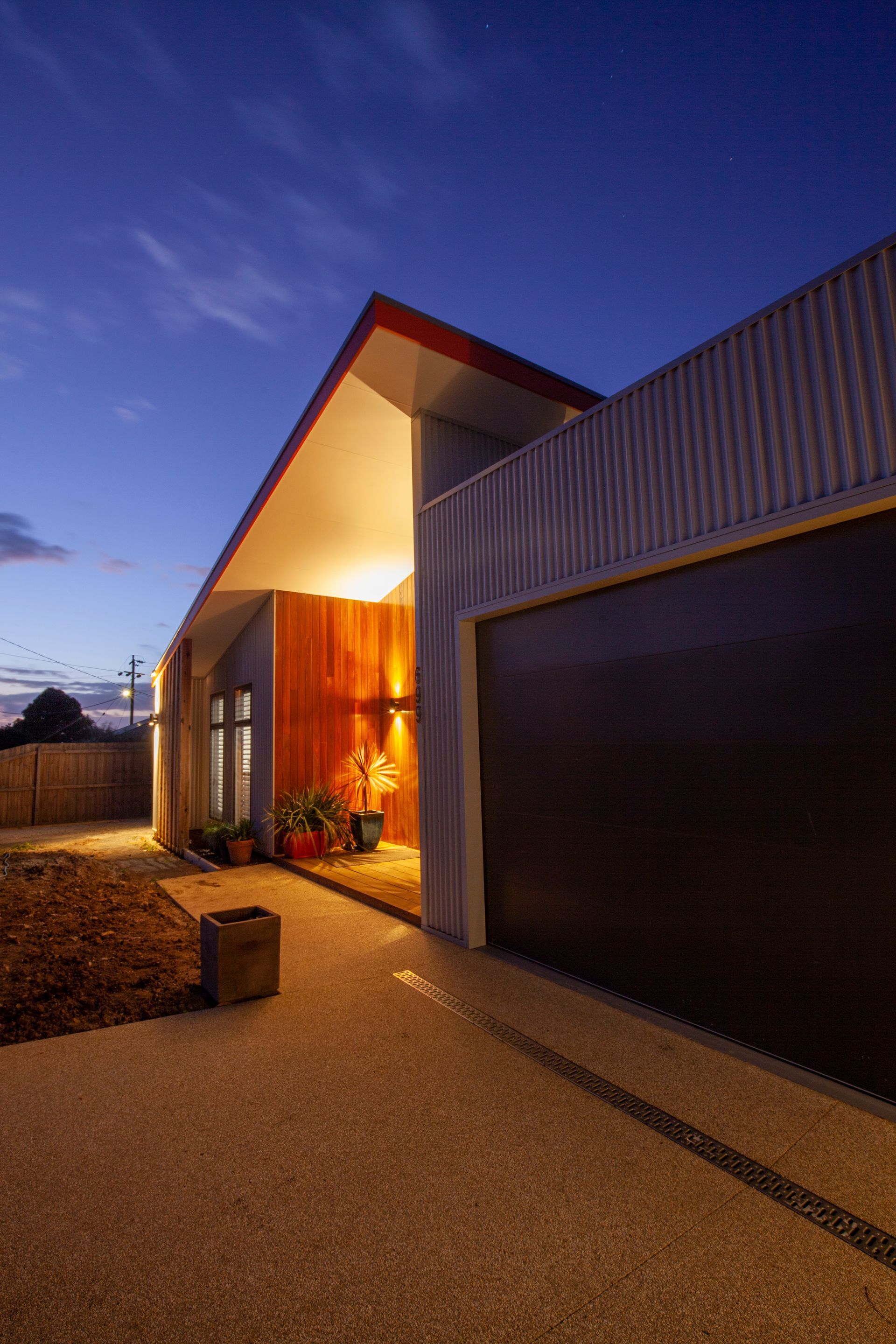 A house with a garage and a driveway at night.