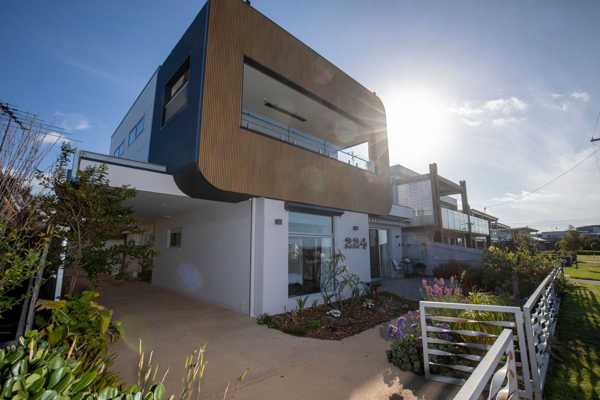 A large white house with a balcony and a fence in front of it.