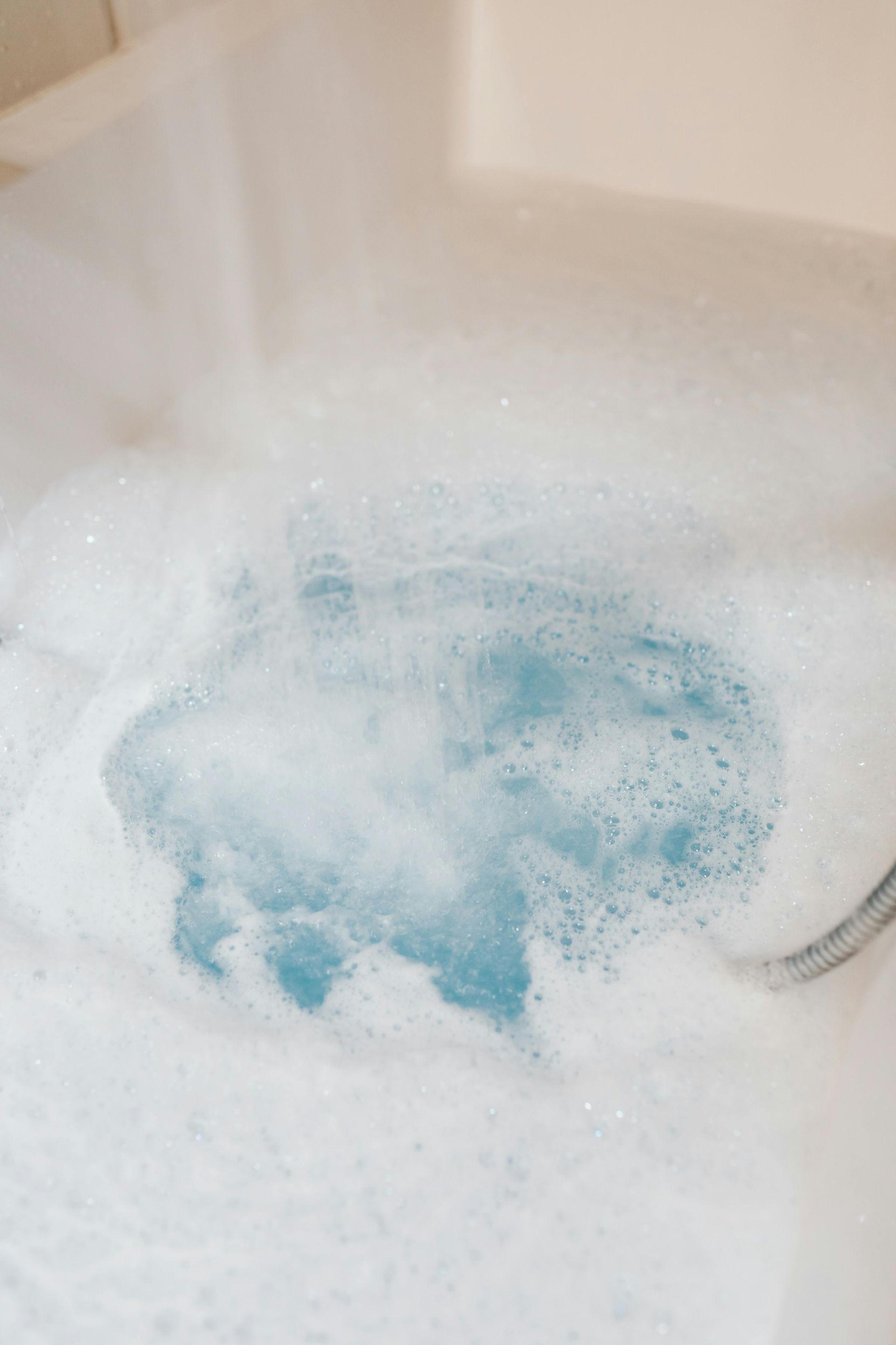 A close up of a bathtub filled with foam and water.