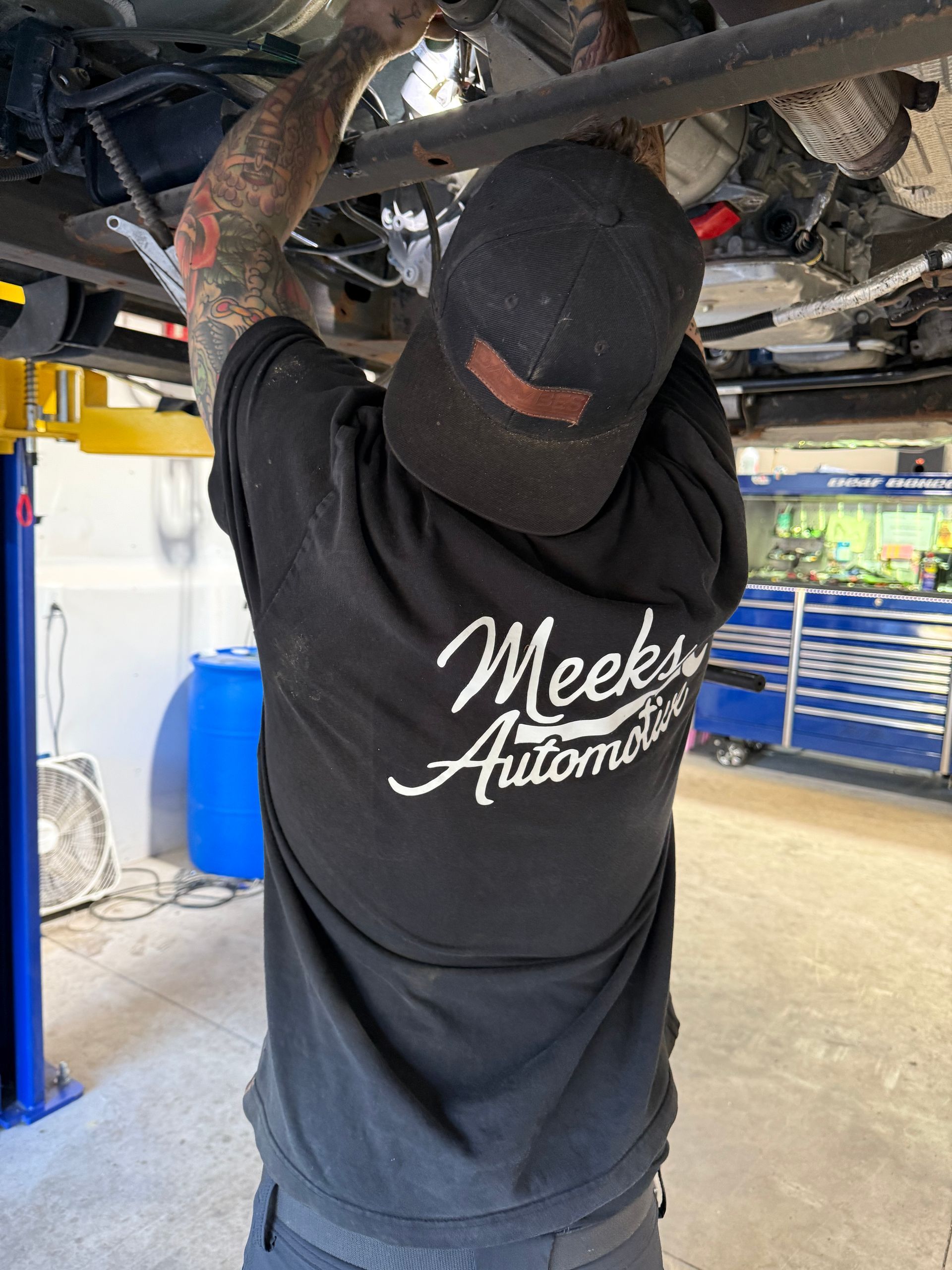 Close-up of a car tire resting on a black parking block; the suspension is visible.