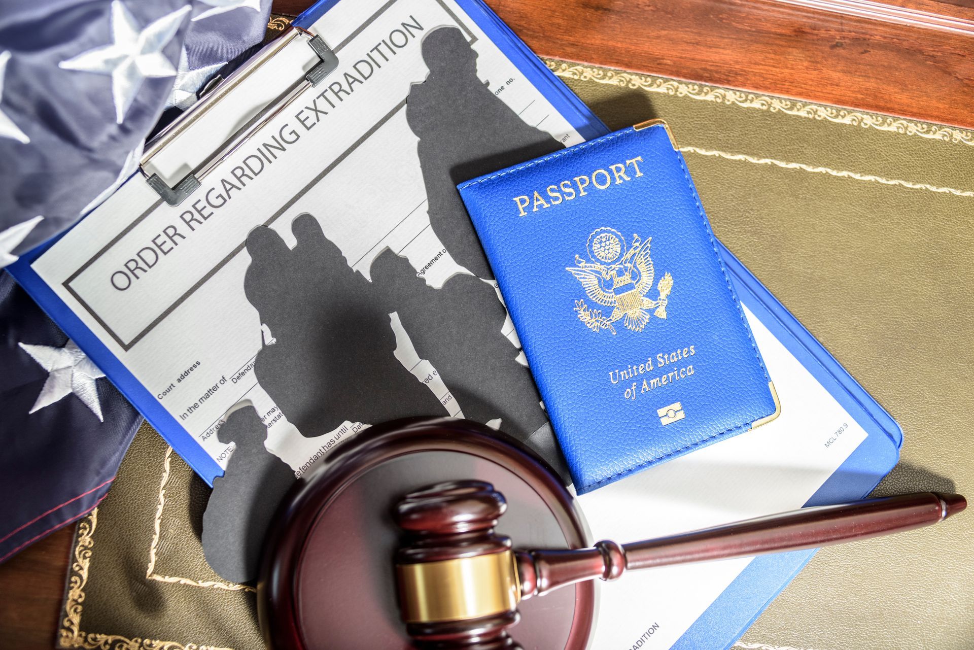 A judge 's gavel is sitting next to a passport and a clipboard.