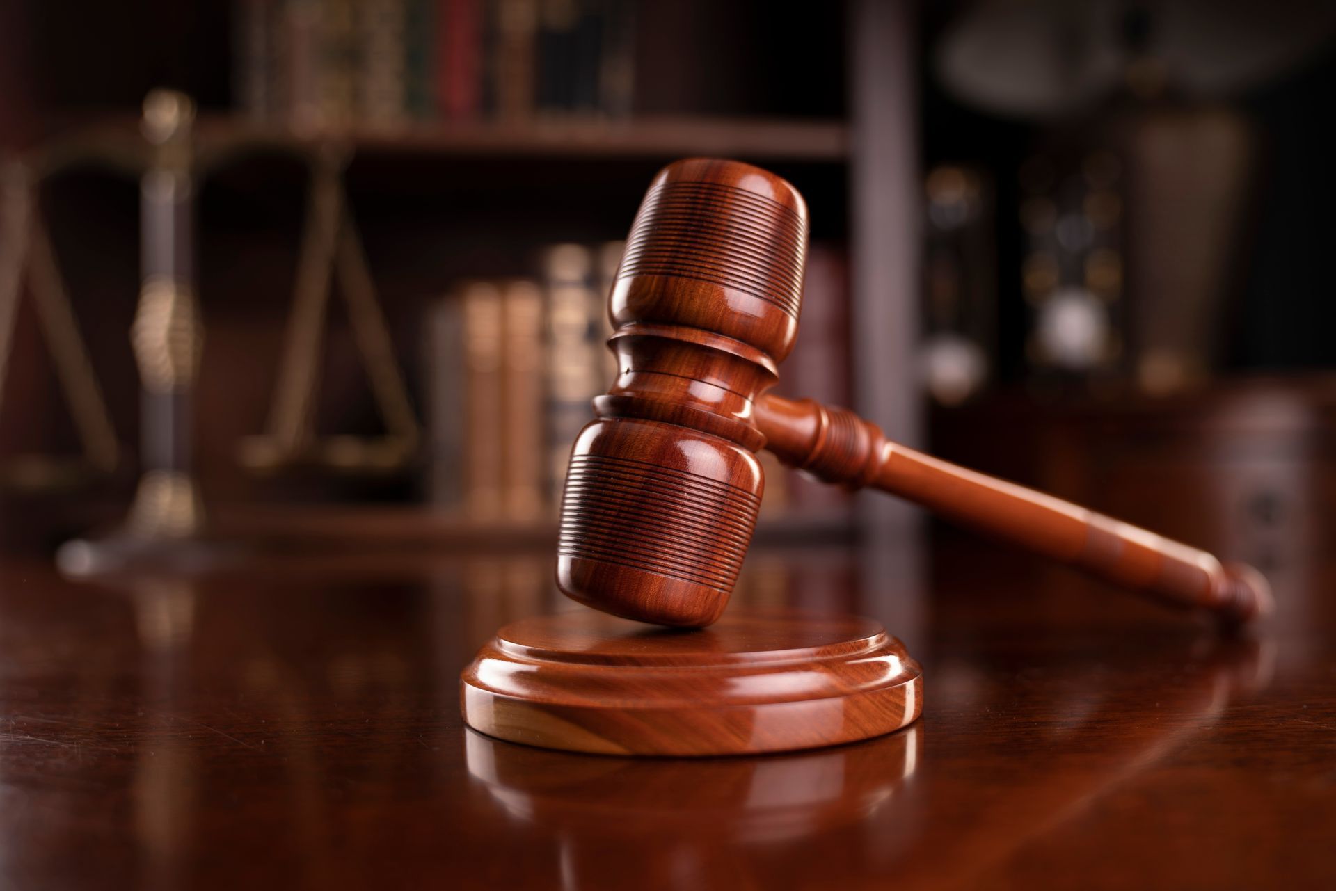 A wooden judge 's gavel is sitting on a wooden table.