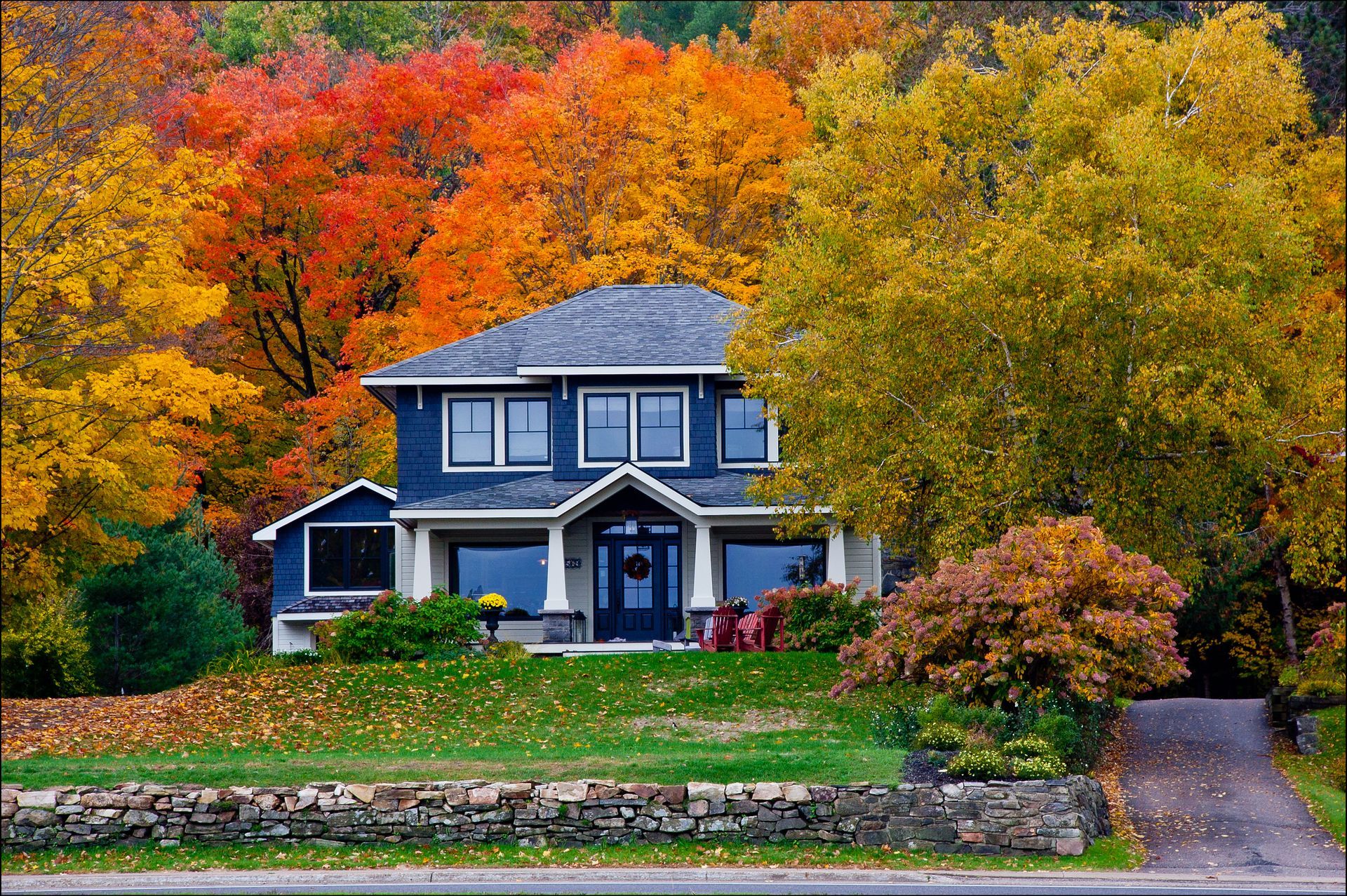 A house surrounded by trees with autumn leaves on them