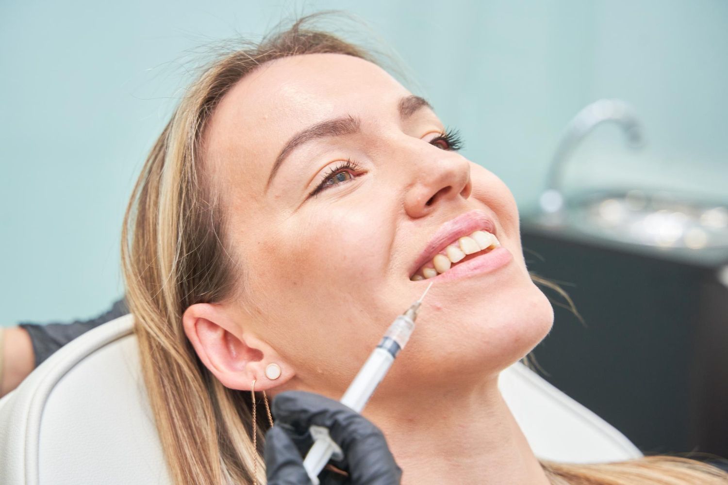 A woman is getting a botox injection in her face.