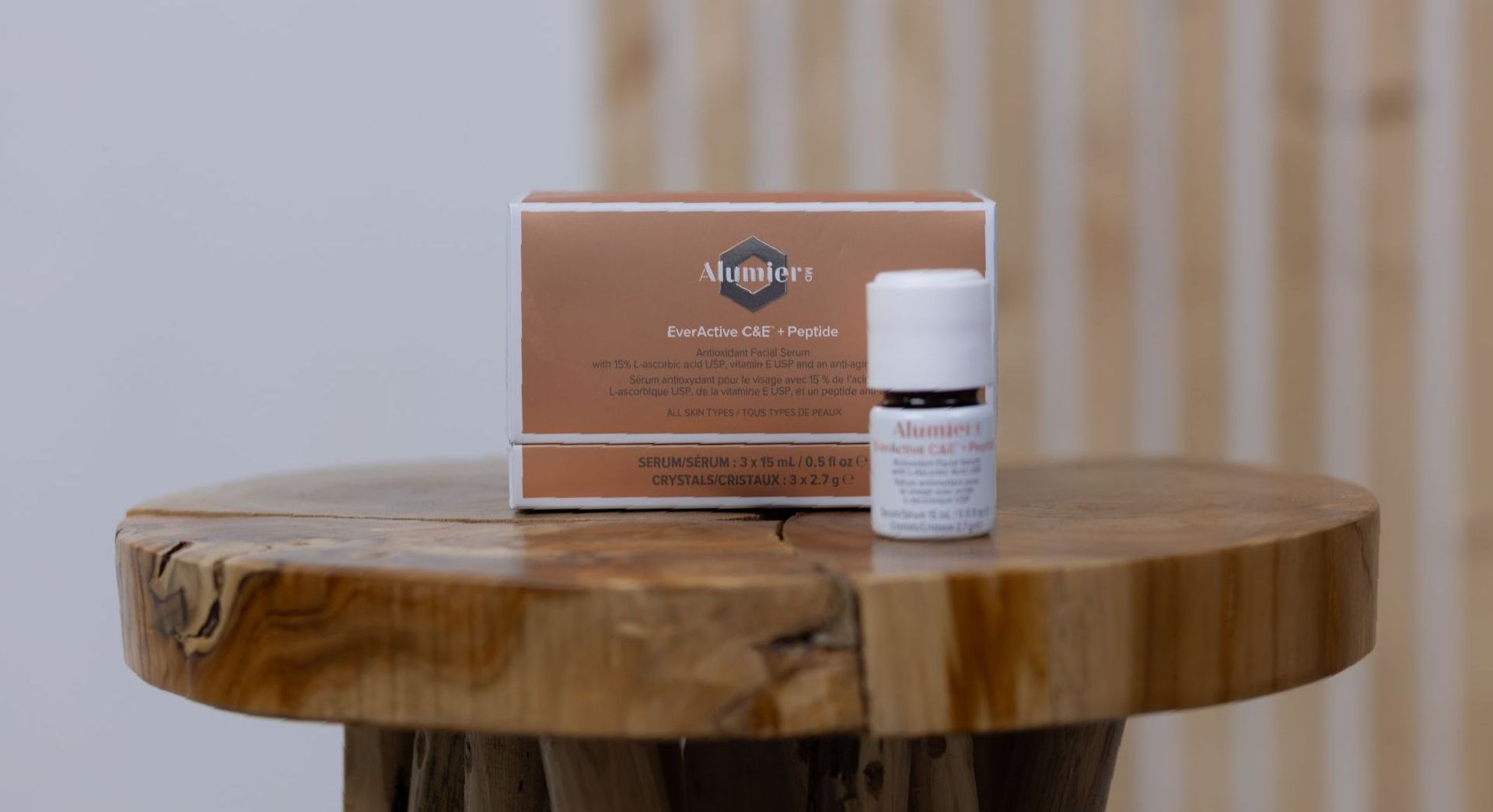 AlumierMD skin care products on wooden stool