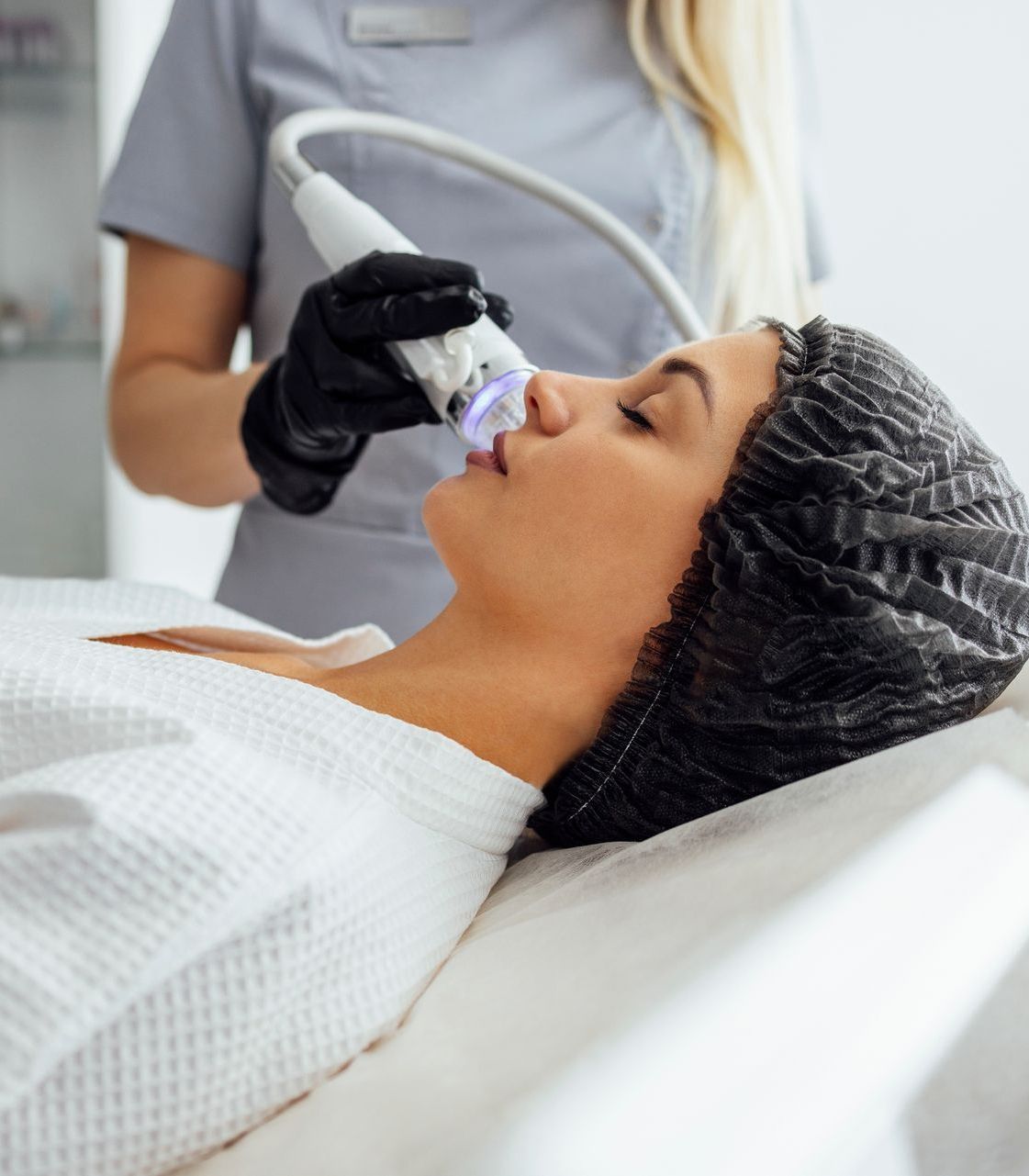 female medical director during RF microneedling facial treatment