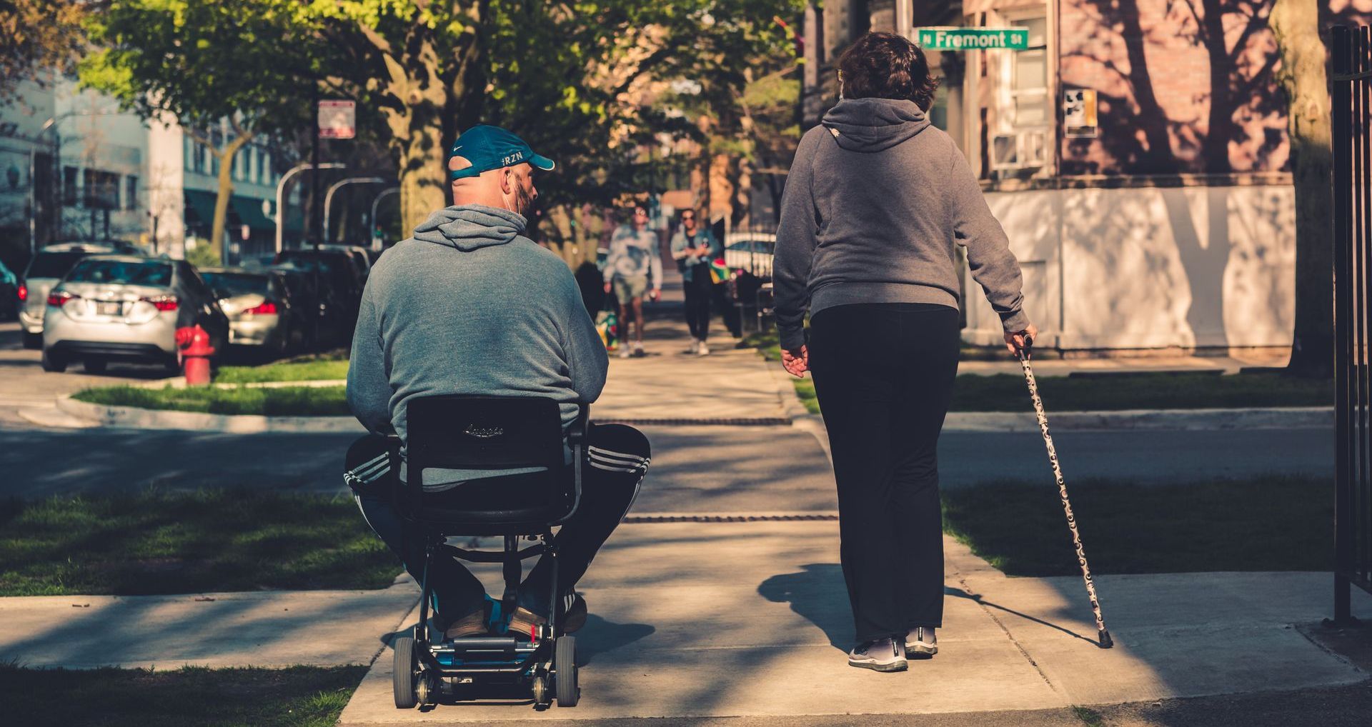 man in scooter with woman using cane