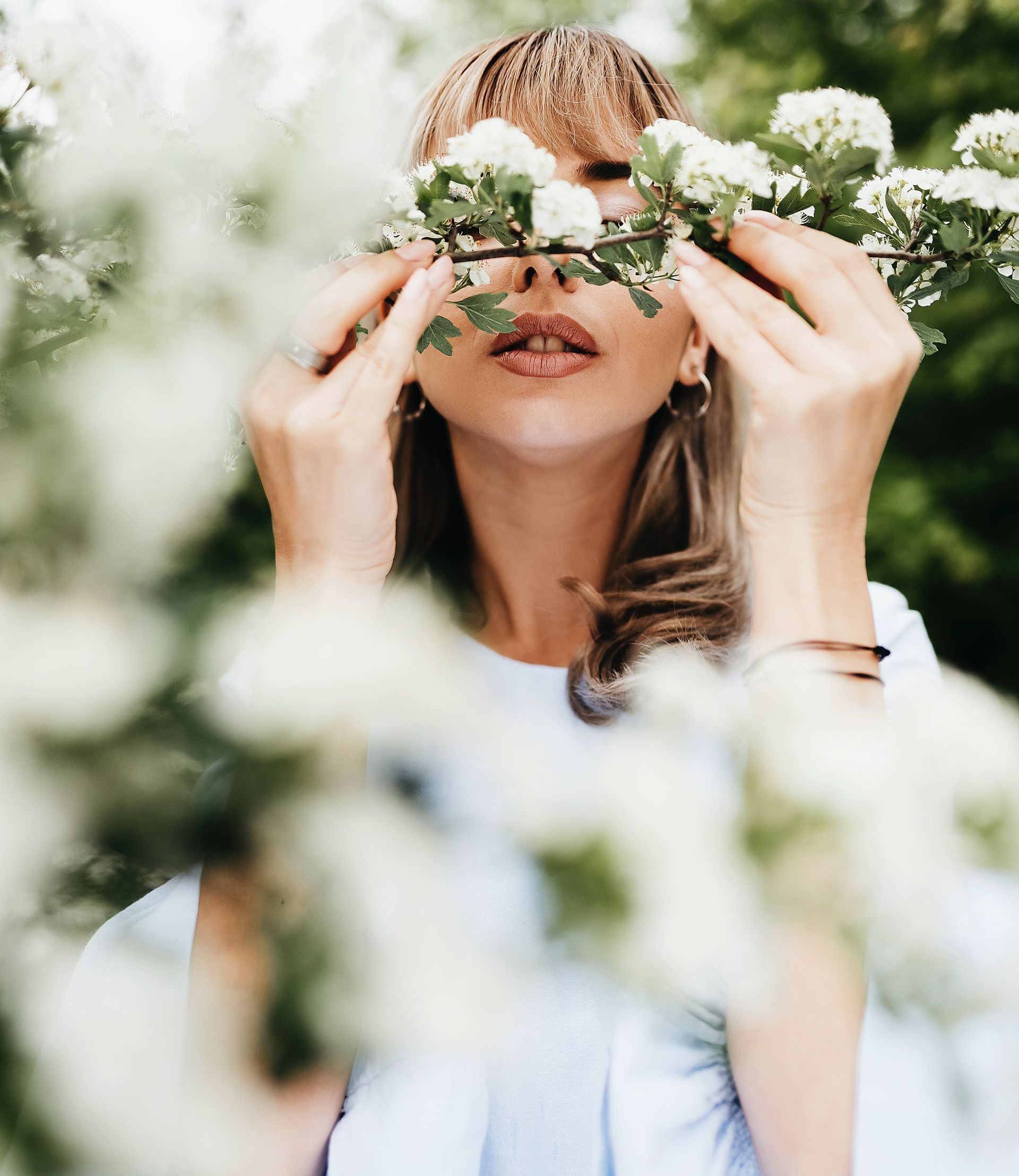 a woman is holding flowers in front of her face.