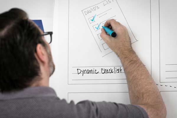 Man in glasses marks off items on