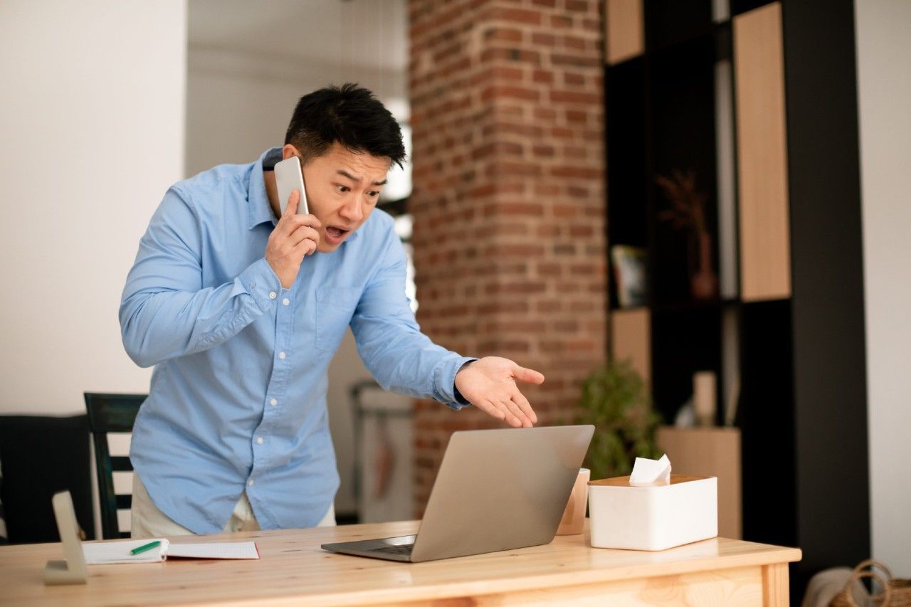 ノートパソコンを前に困惑するビジネスオーナー