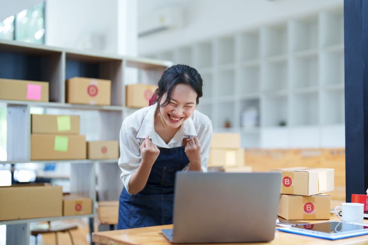 Business owner in Japan smiling after successfully generating online inquiries