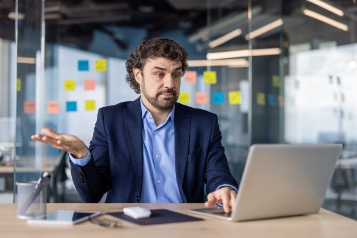 Small business owner in Japan looking confused while working on a laptop