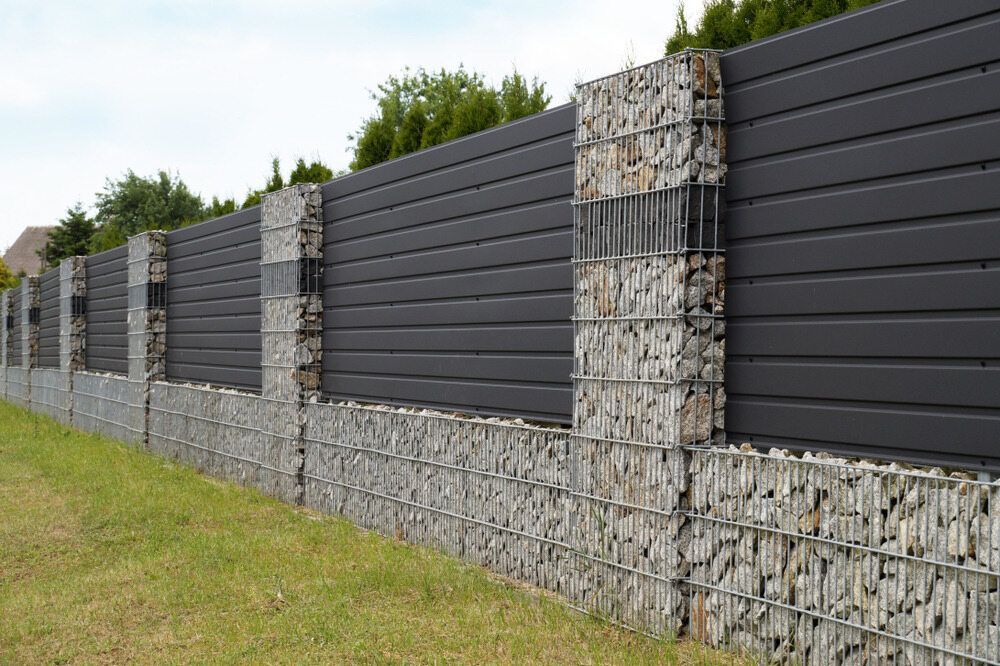 There is a Fence Made of Rocks and a Metal Fence — Lakecrest Projects in Lake Macquarie, NSW