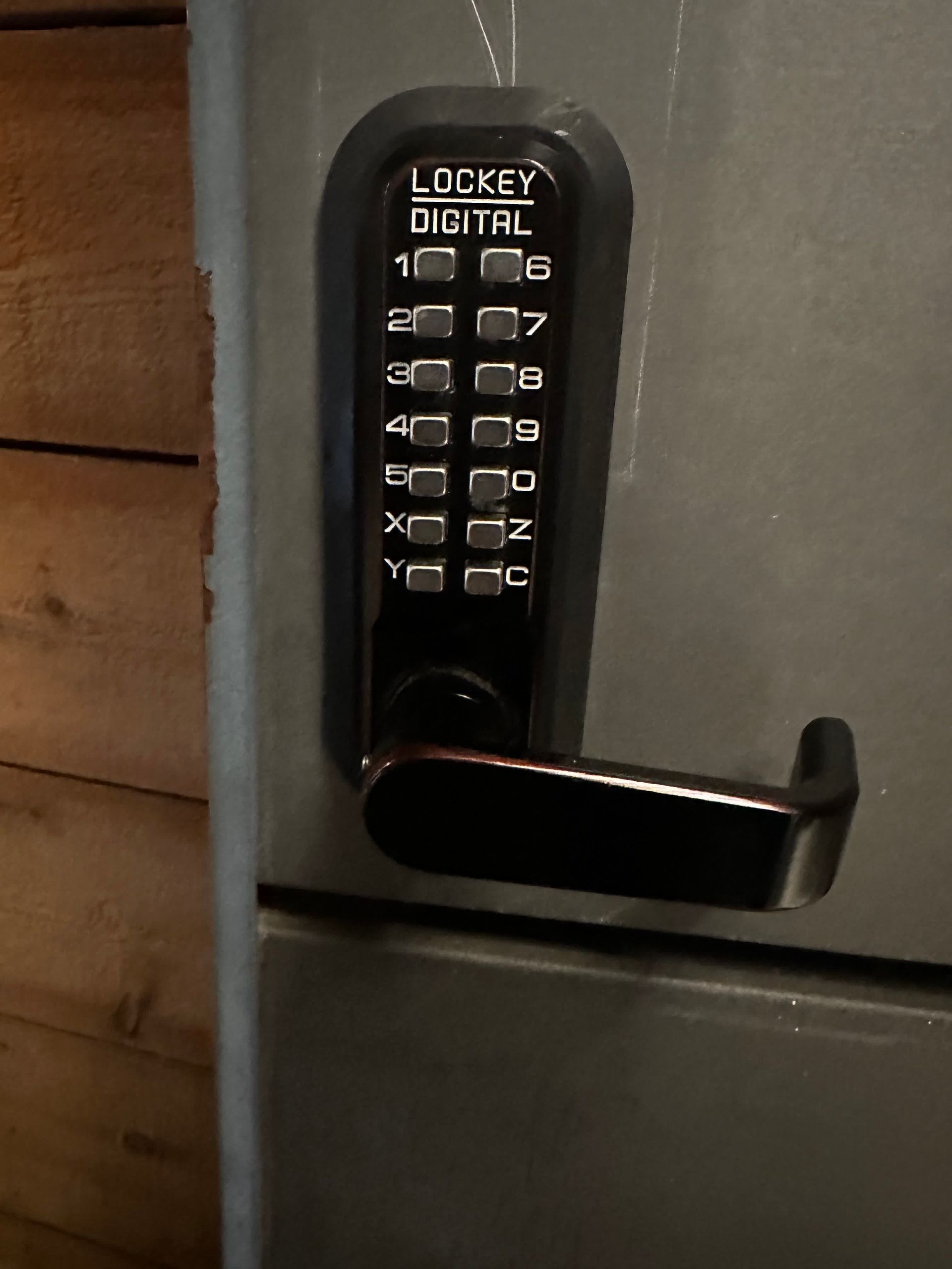 Hand and digital smart code lock on the door of a modern apartment.