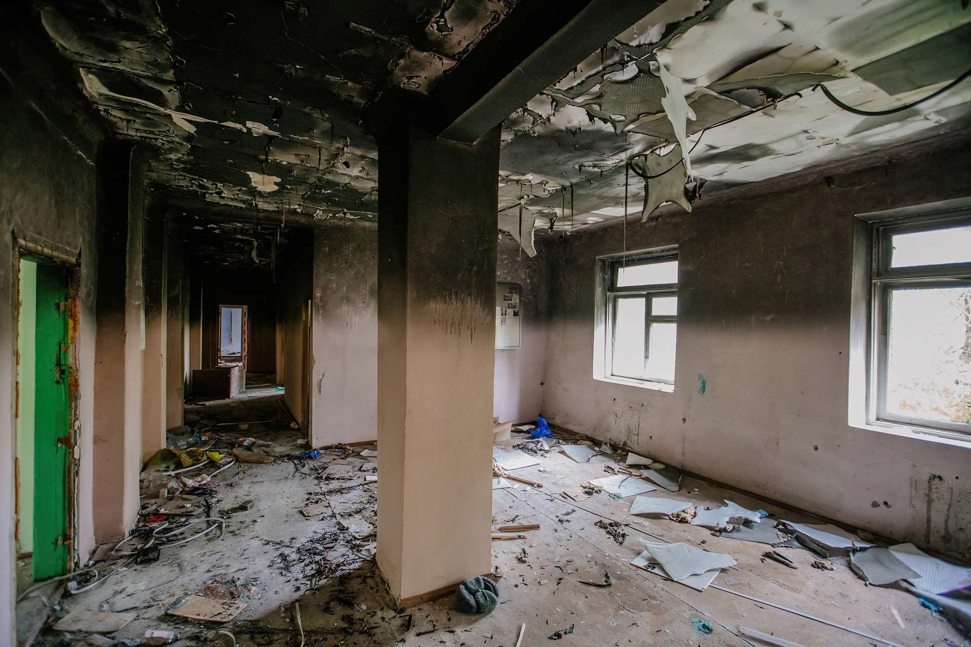 Water on dark hardwood floor near a window, with a rug partially visible.