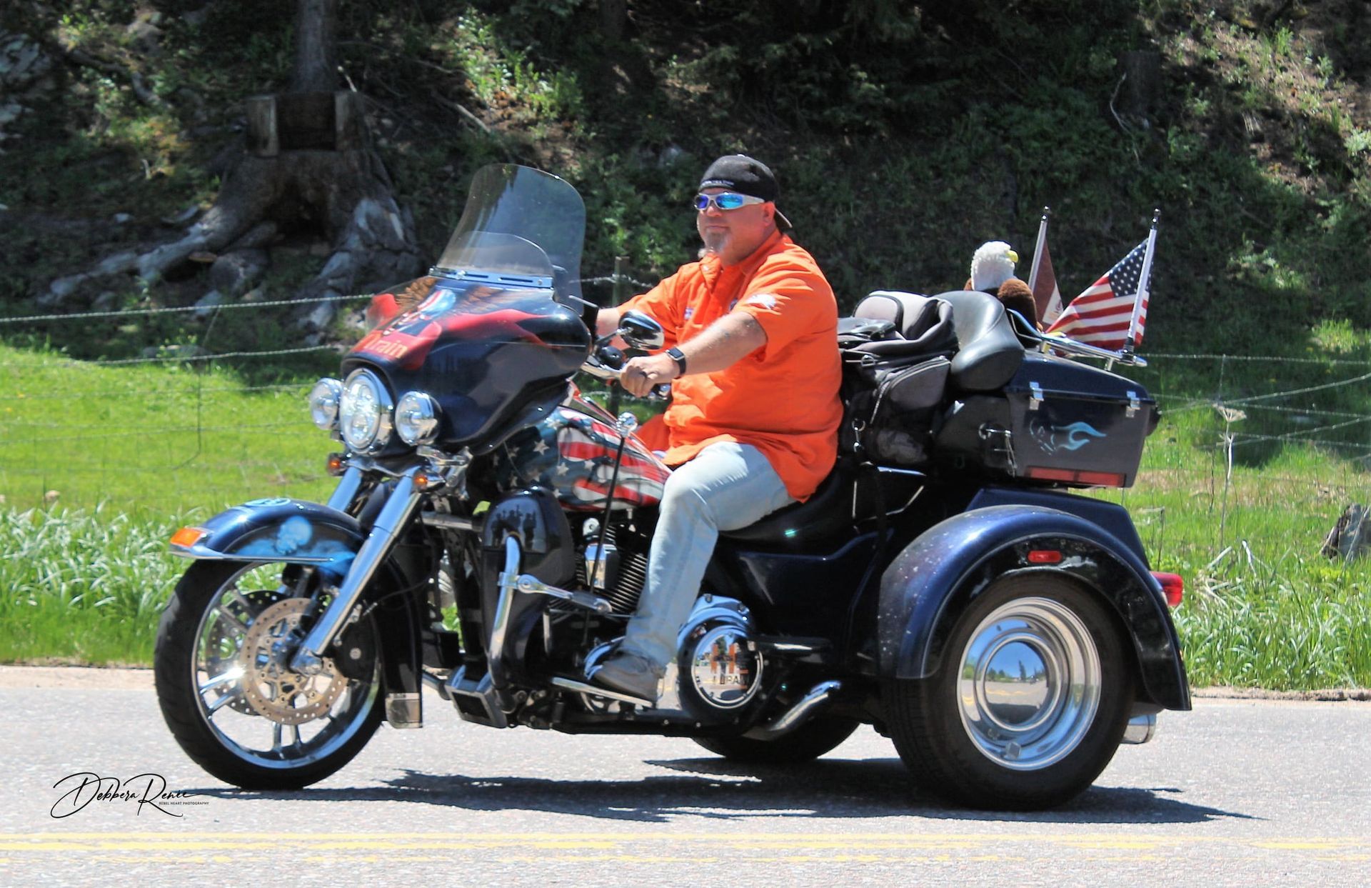 A man is riding a motorcycle with three wheels on the road.