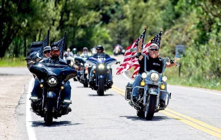 A group of people are riding motorcycles down a road.