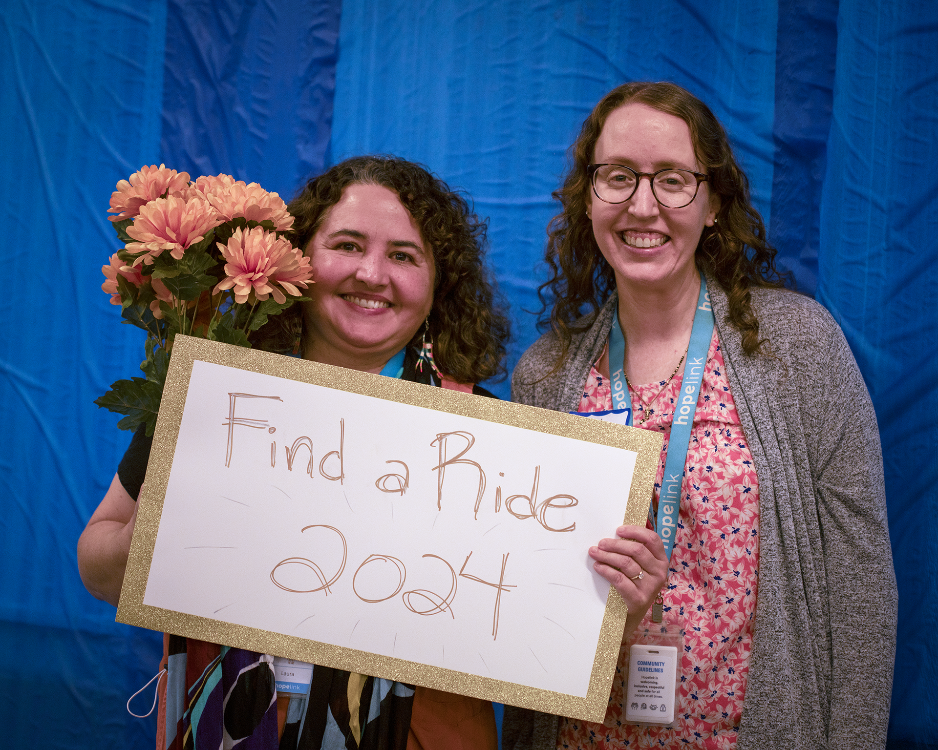 Two people holding a Find a Ride 2024 sign