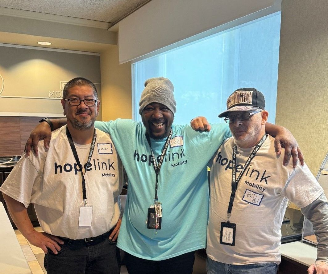 Three men are posing for a picture together in a room.