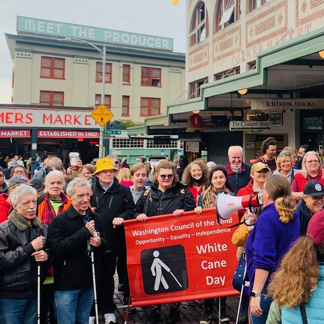 People gathered at Pike Place Market with a banner that says White Cane Day