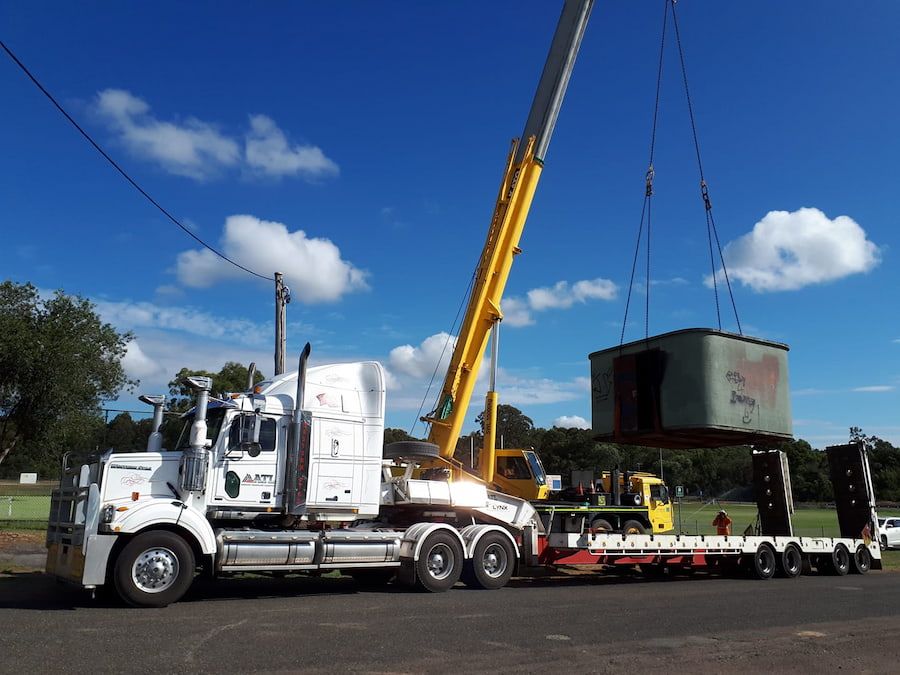 A Semi Truck Is Being Lifted By A Crane — Armour Transport Logistics In Singleton, NSW