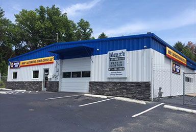 Hart's Automotive Repair Center: blue and white building with a garage door and sign, gray stone accents. | Emge's Car Craft Auto Services