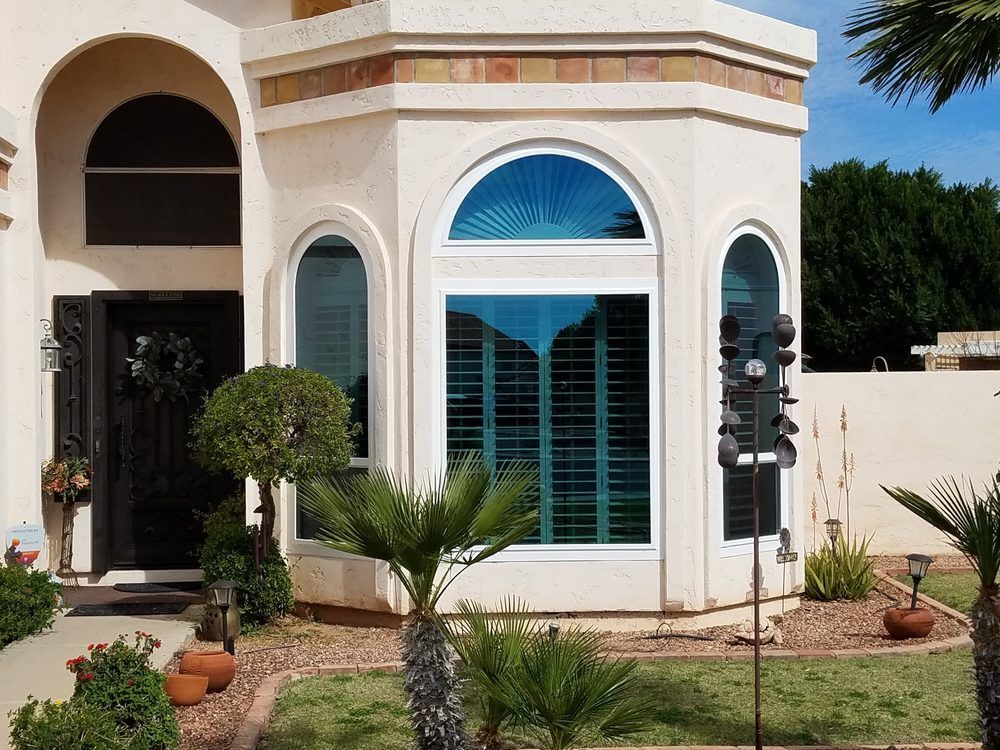 The front of a house with a large window and shutters