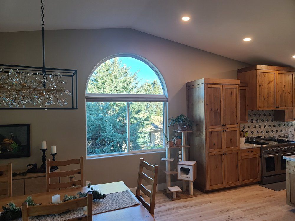 A kitchen and dining room in a house with a large window.