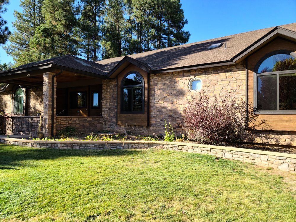 A large brick house with a large lawn in front of it.