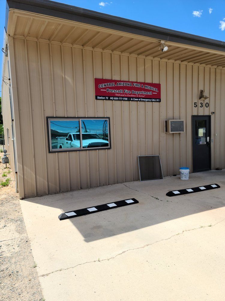A tan building with a red sign that says ' jesus ' on it