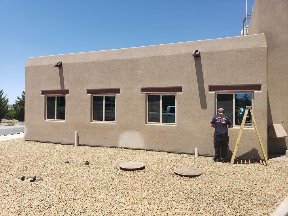 A man standing in front of a building with a ladder