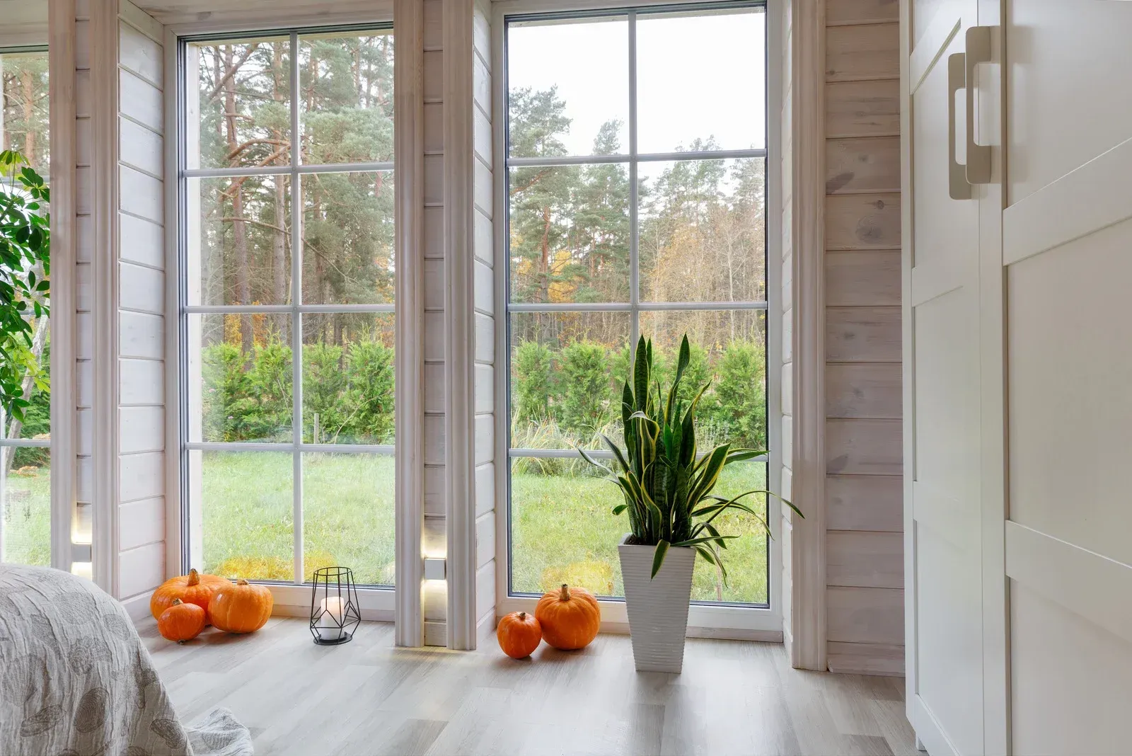A man is writing on a piece of paper in front of a window