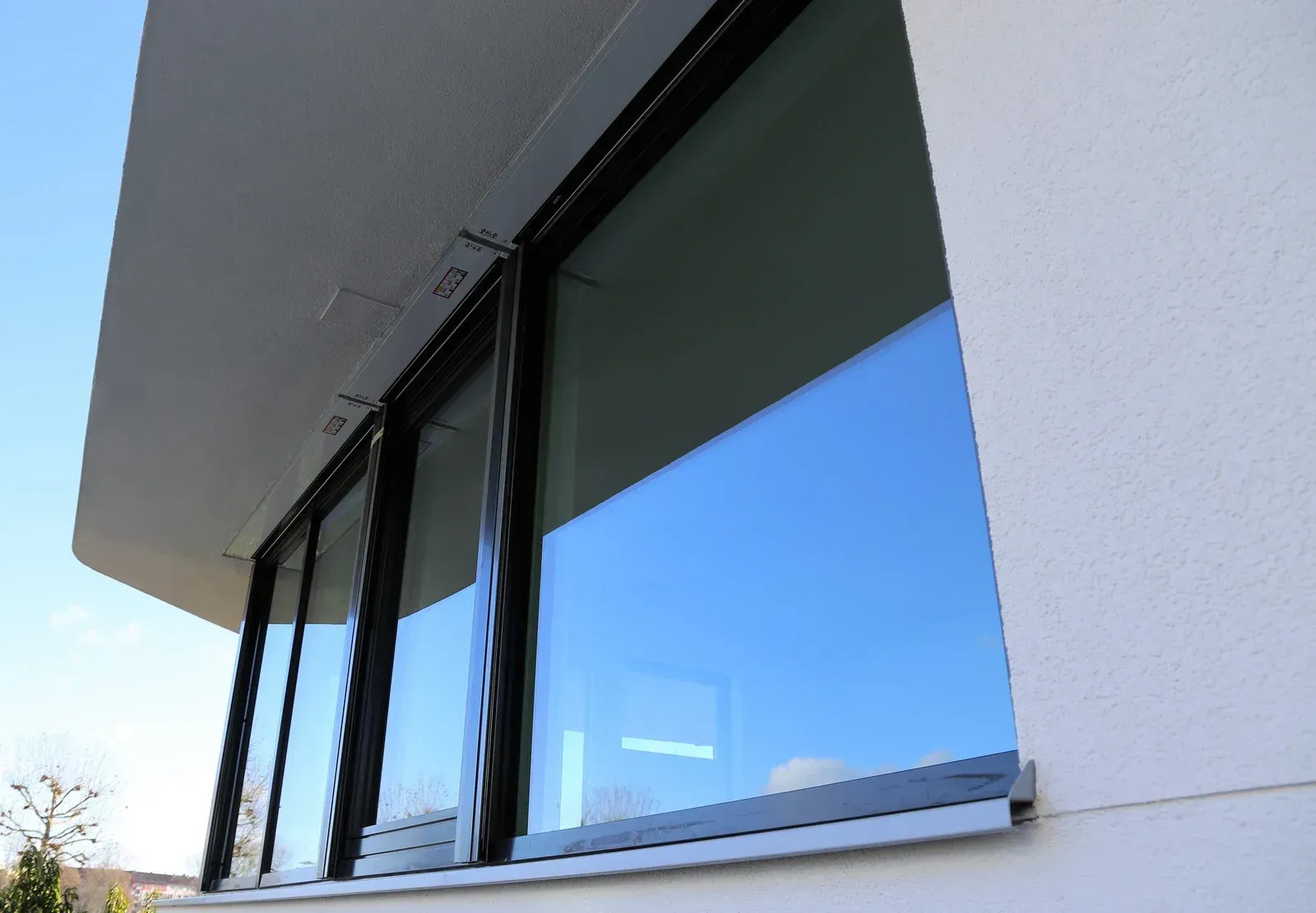 A man is looking out a window while holding a clipboard