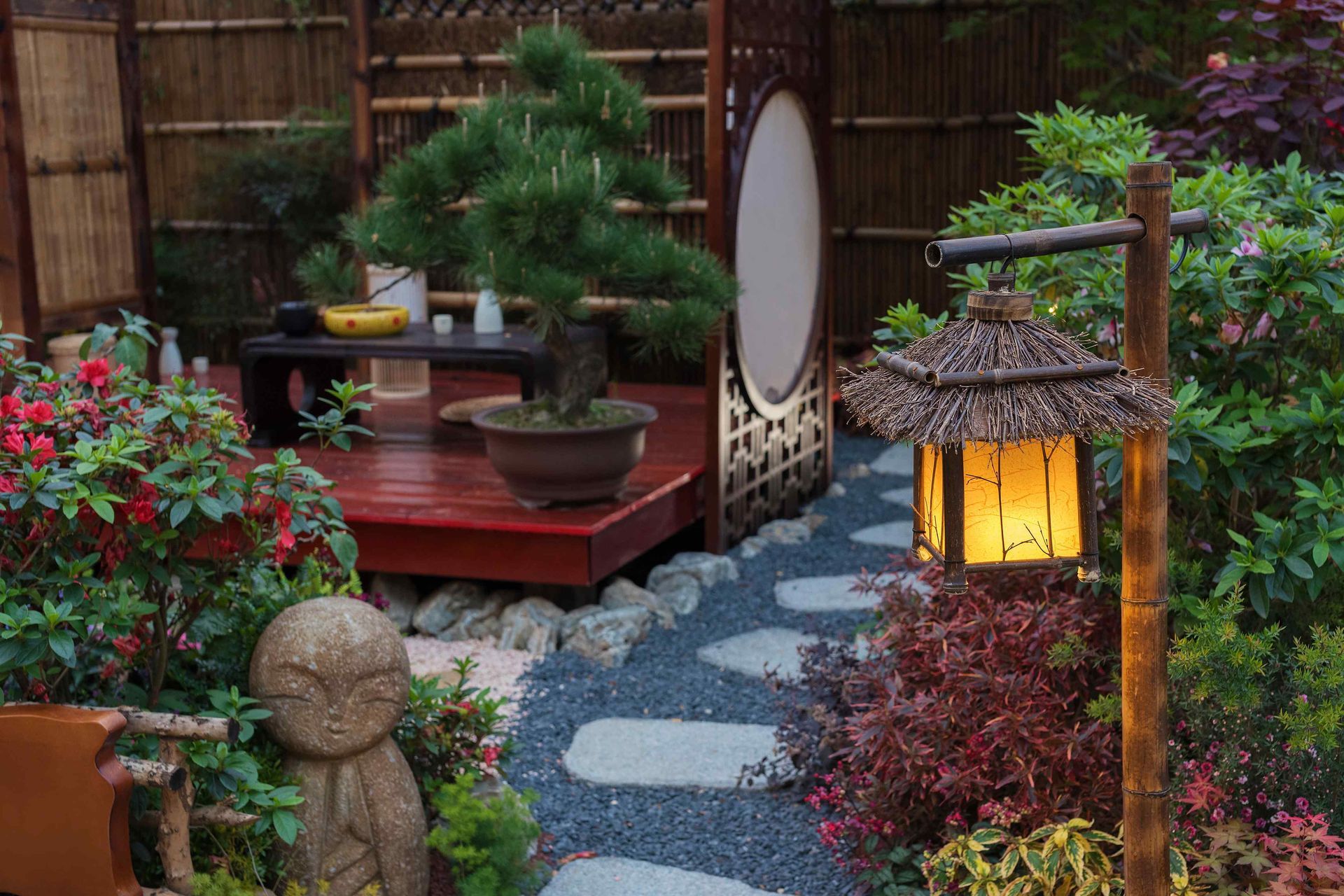 A zen-inspired garden oasis illuminated by a lantern.