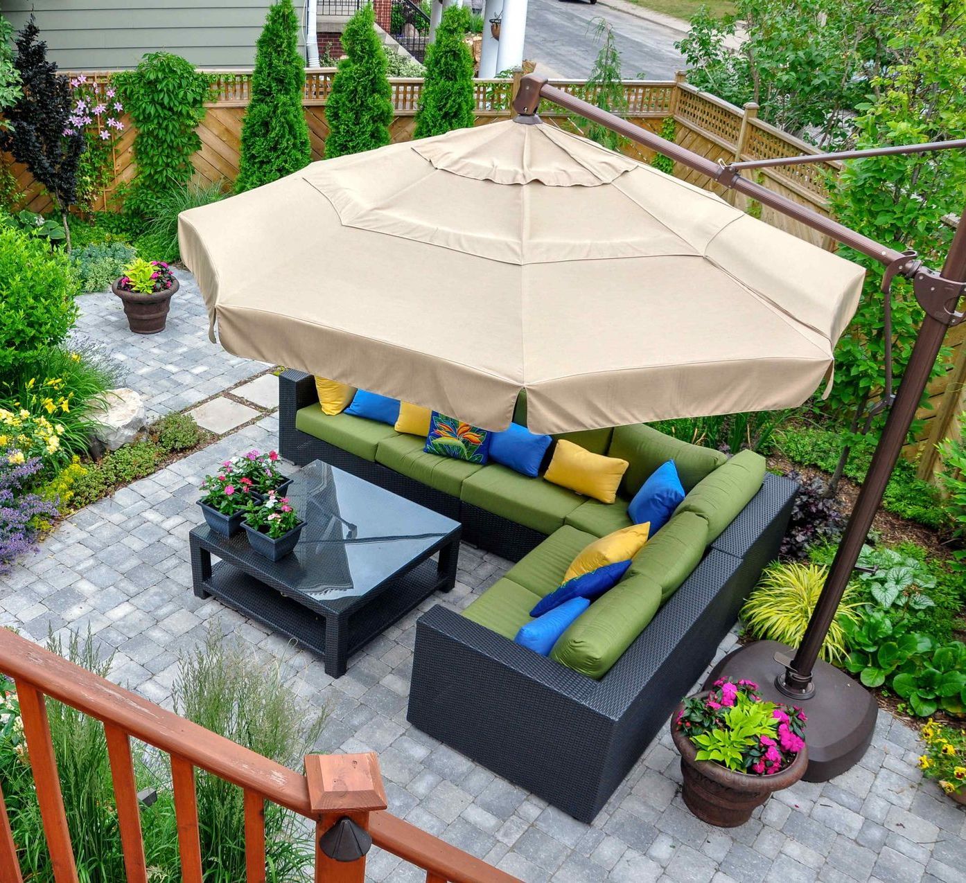 An aerial view of a beautiful hardscape with seating and an umbrella for lounging.