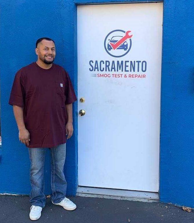 Billy standing in front of a door that says Sacramento Smog Test and Repair