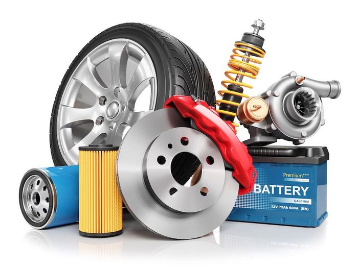 A variety of car parts , including a tire , brake pads , shock absorbers , and a battery.