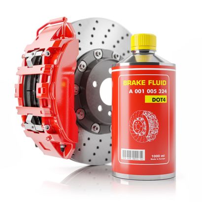 A bottle of brake fluid next to a brake disc