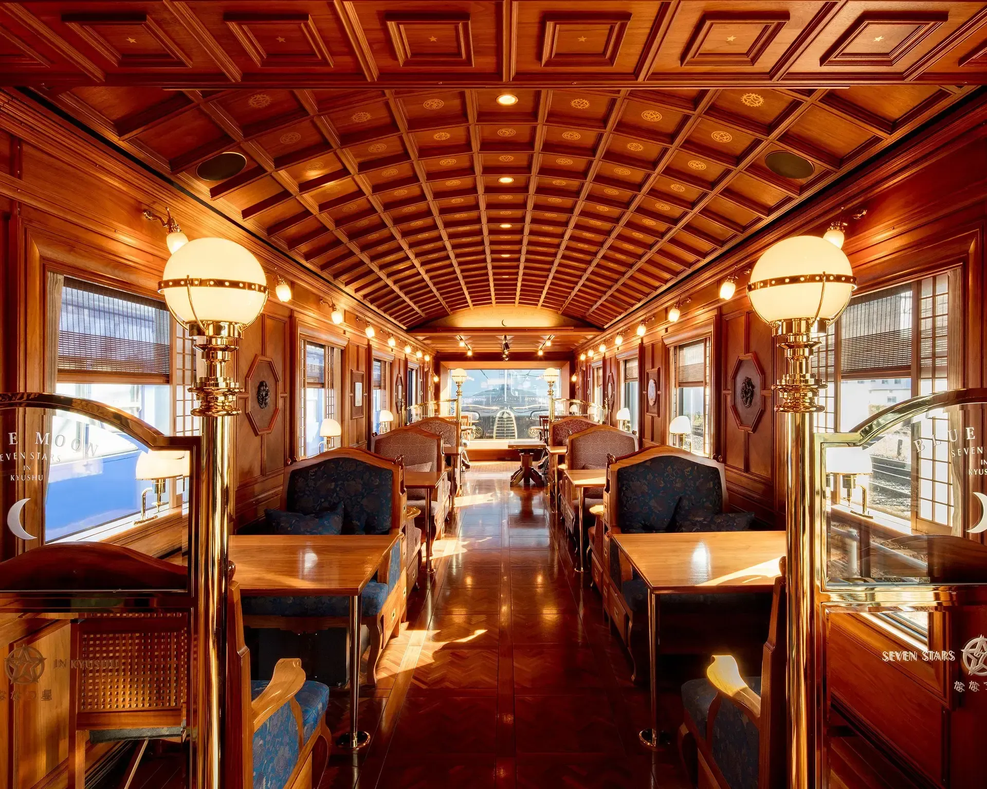 Train traveling through grassy field with deer running alongside tracks. Sunny day.