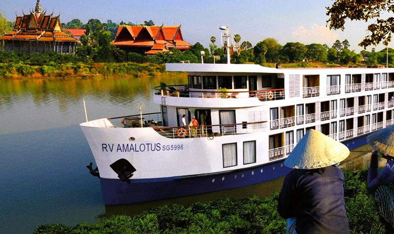 RV Amalotus river cruise boat on a river in Southeast Asia, with a person in a conical hat in the foreground.