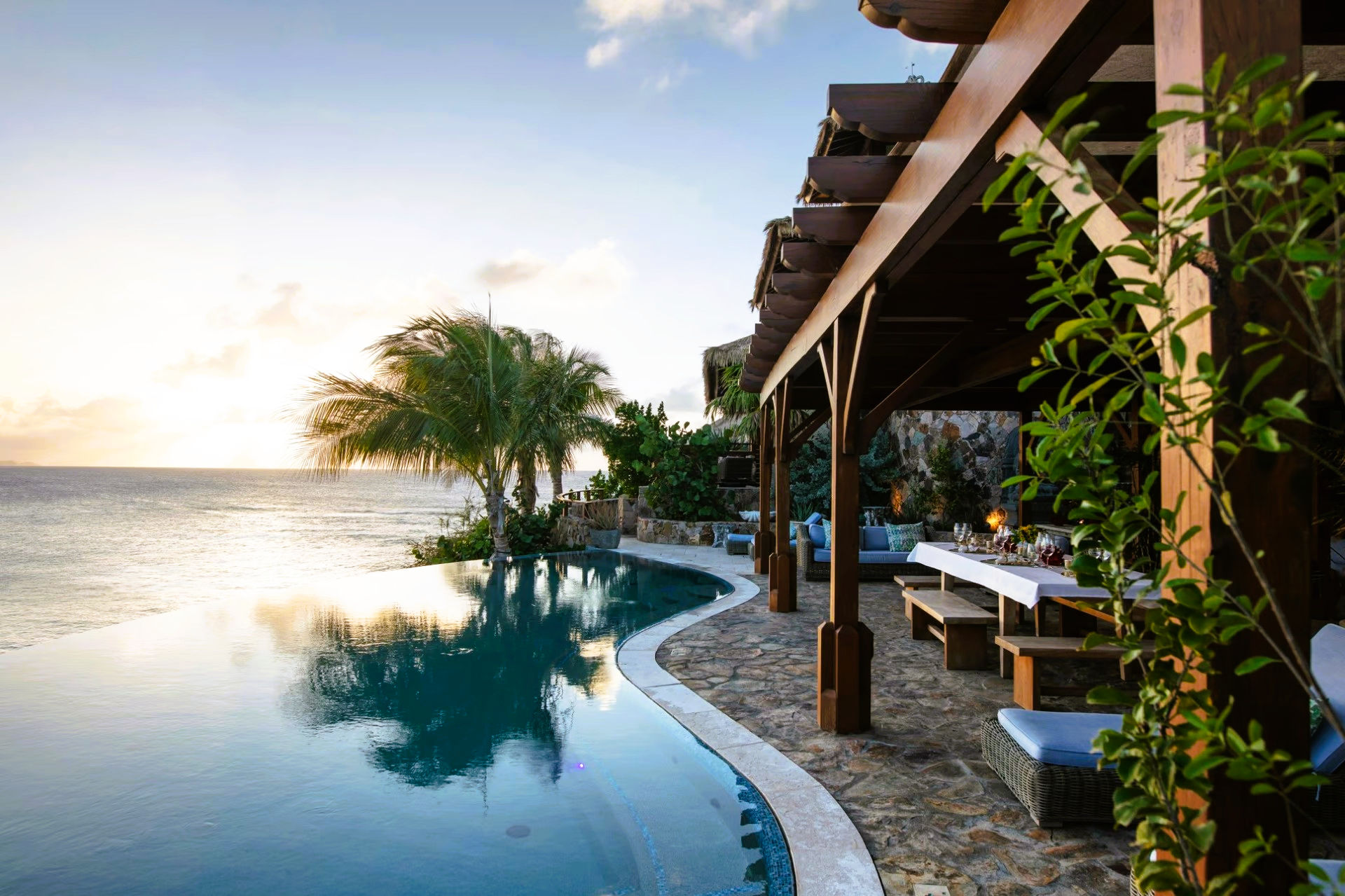 A large swimming pool with a pergola overlooking the ocean