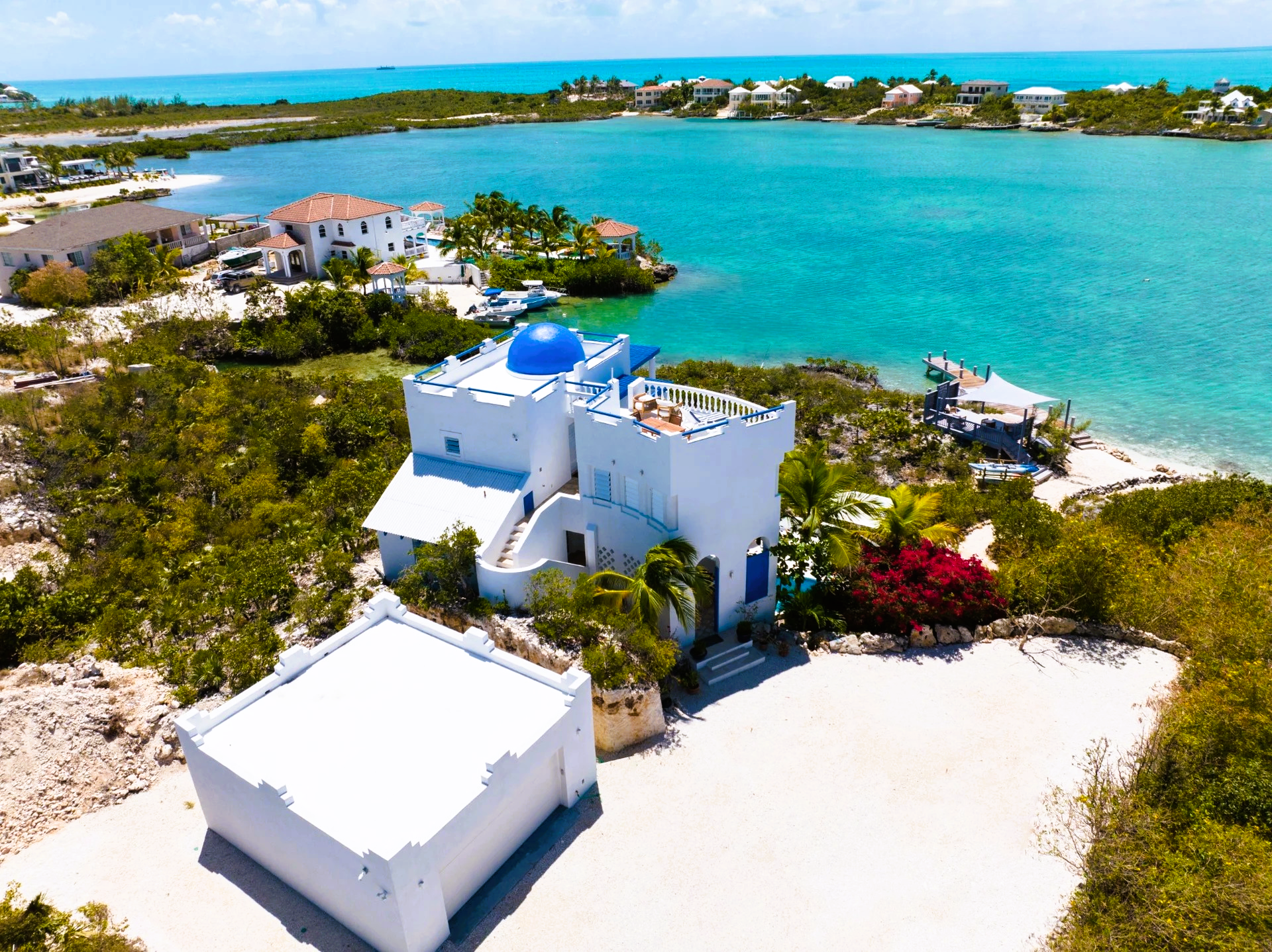 An aerial view of a white house with a blue dome on top