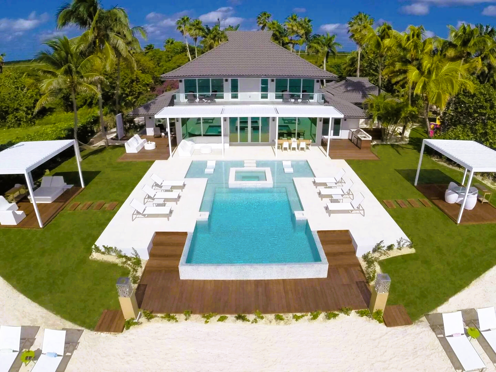 An aerial view of a large house with a large swimming pool