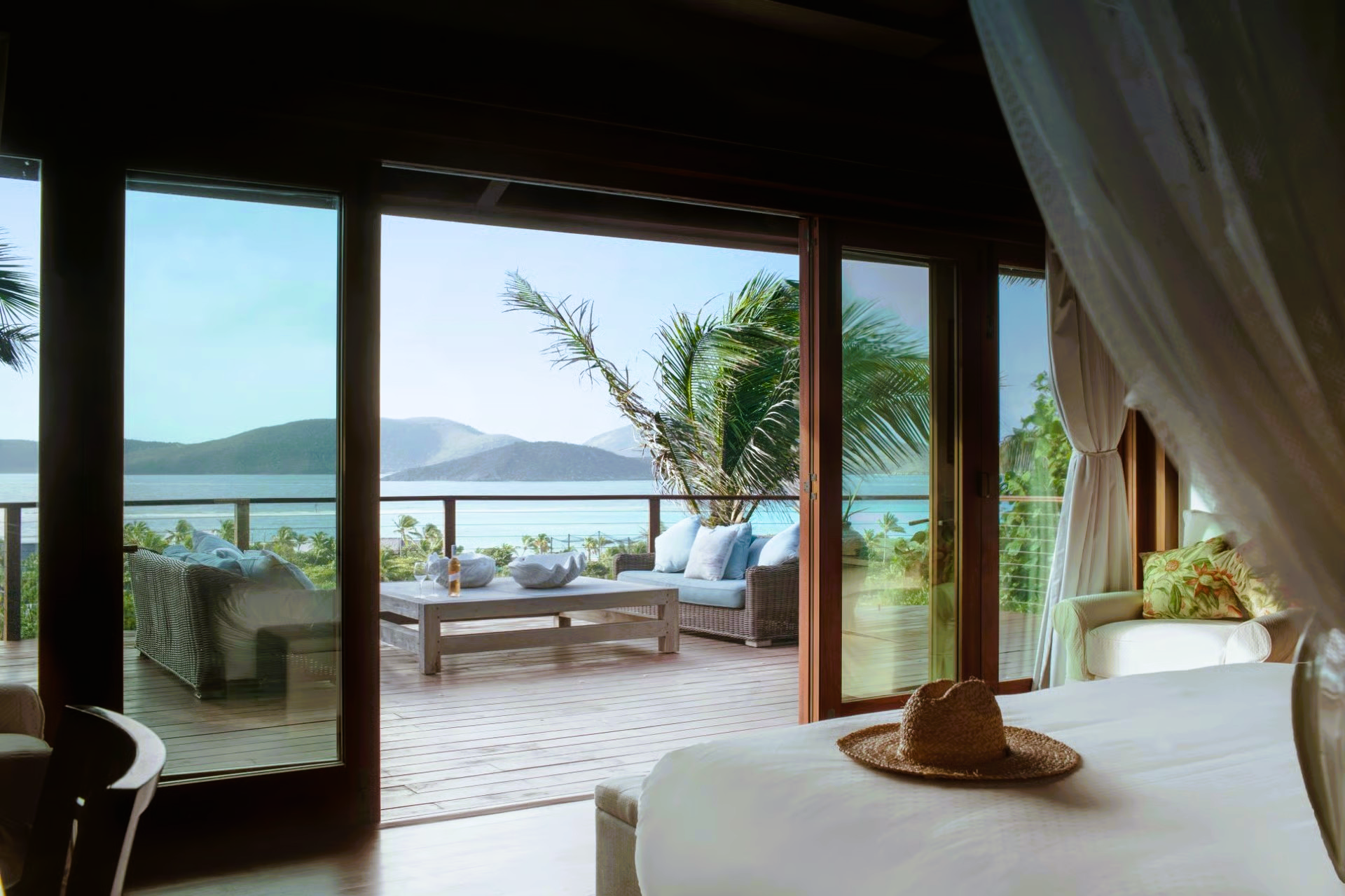 A bedroom with a canopy bed and a view of the ocean.