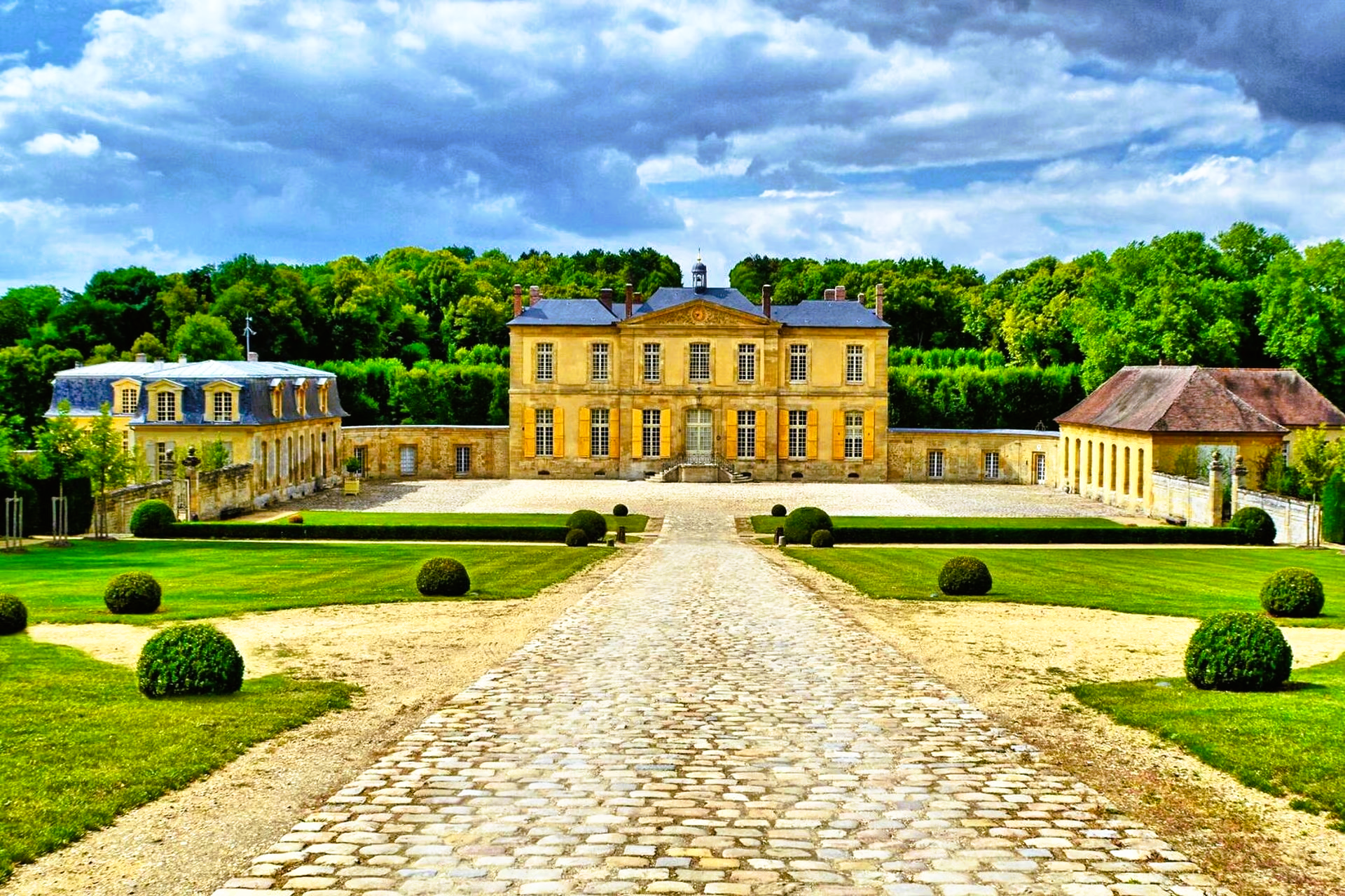 There is a large building in the middle of a lush green field.