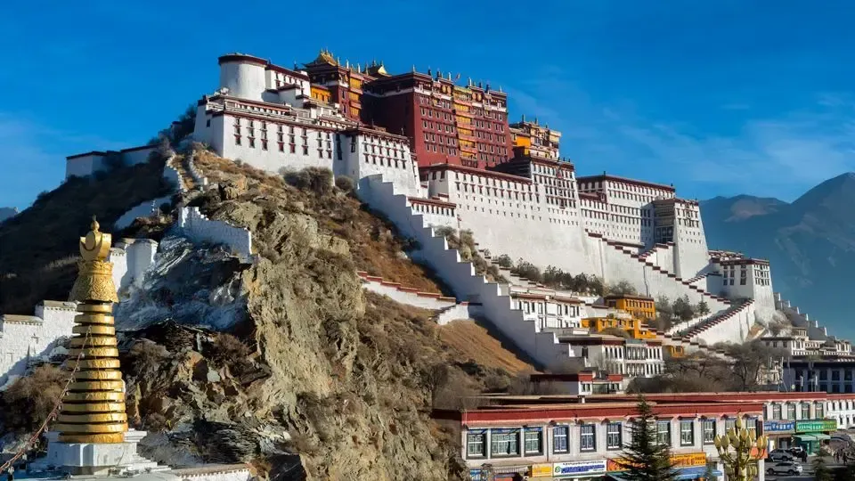 Potala Palace, Lhasa, Tibet, a large white and red fortress on a hillside, under a blue sky.