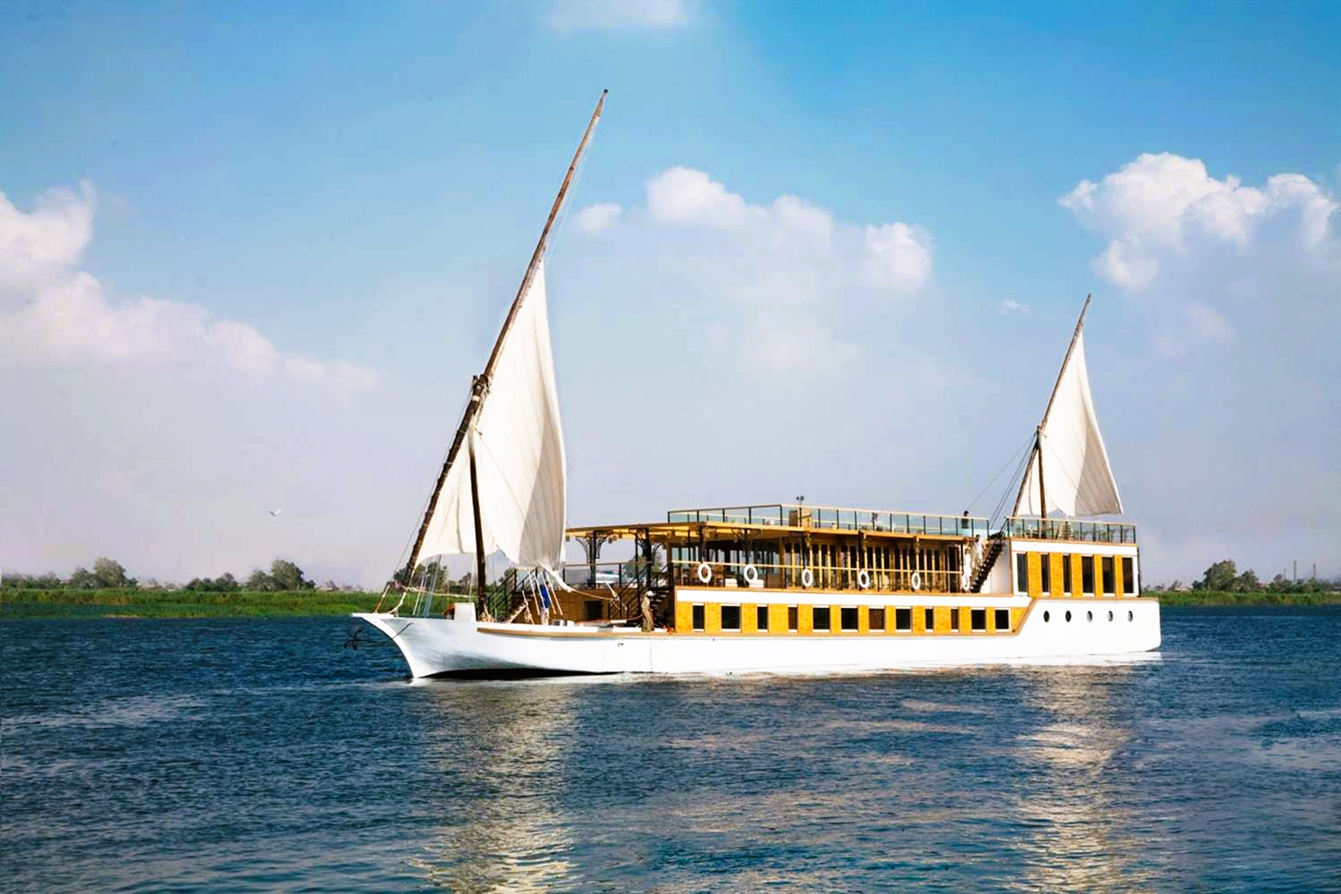 RV Amalotus river cruise boat on a river in Southeast Asia, with a person in a conical hat in the foreground.