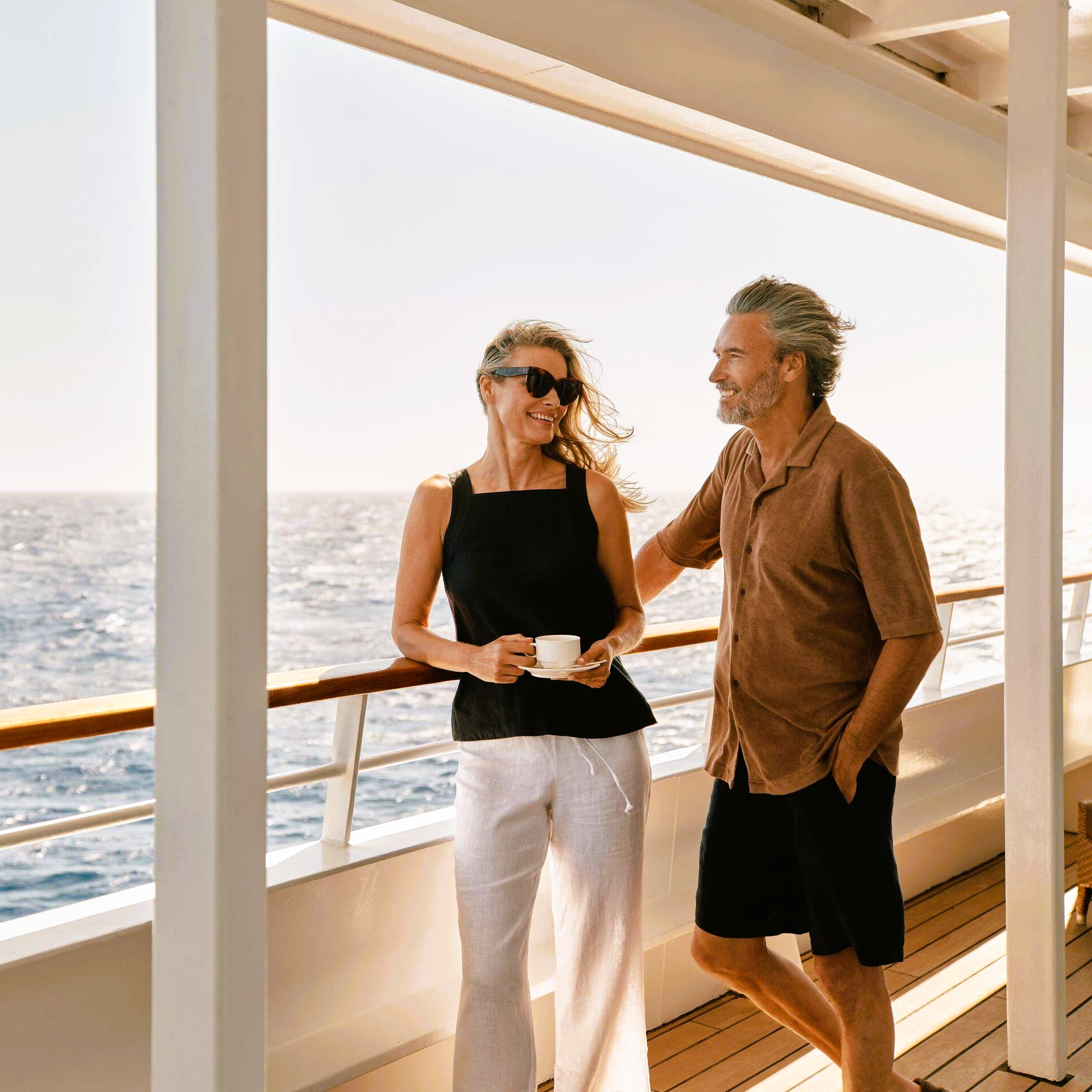 RV Amalotus river cruise boat on a river in Southeast Asia, with a person in a conical hat in the foreground.