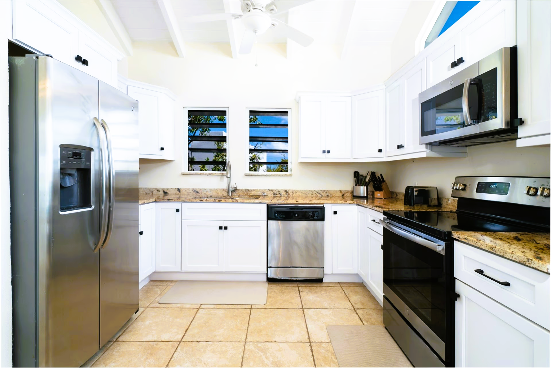 A kitchen with stainless steel appliances and white cabinets